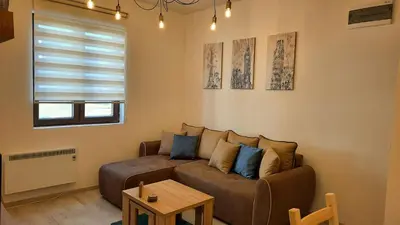 a living room with a couch and a table at Apartman Ema in Kopaonik