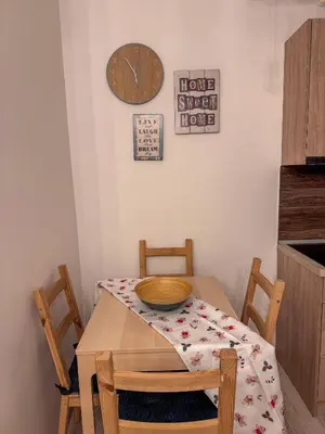 a dining room table with two chairs and a clock on the wall at Apartman Ema in Kopaonik