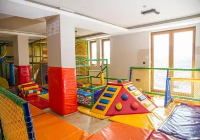 a childrens play room with colorful equipment in a room at Dream Milmari L12 Apartman in Kopaonik
