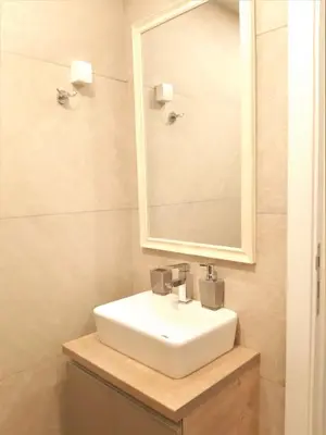 a bathroom with a white sink and a mirror at Dream Milmari L12 Apartman in Kopaonik
