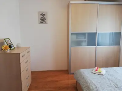 a bedroom with a bed and a dresser and a closet at Apartman Breza in Kruševac