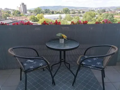 a table with two chairs and a table with a vase at Apartman Breza in Kruševac