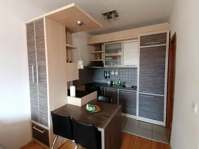 a small kitchen with a wooden table and chairs at Apartman Breza in Kruševac