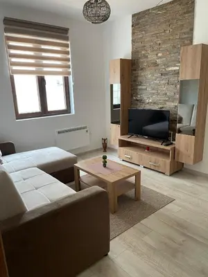 a living room with a couch and a tv at Kraljevi Konaci -Apartmani Bajka in Kopaonik
