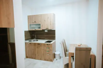 a small kitchen with a sink and a table at Kraljevi Konaci -Apartmani Bajka in Kopaonik