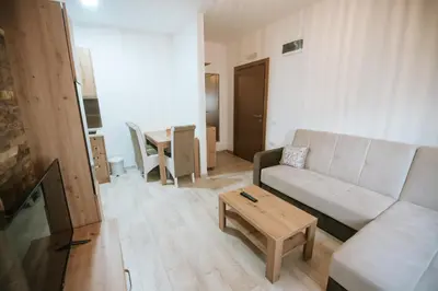a living room with a white couch and a table at Kraljevi Konaci -Apartmani Bajka in Kopaonik