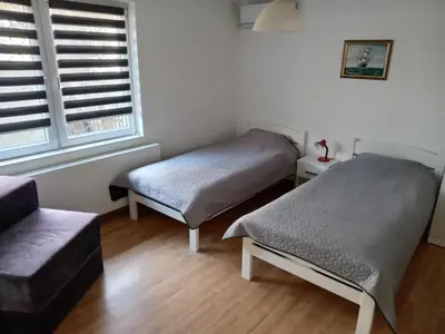 a room with two beds and a window at APARTMAN “POD KRALJEVICOM” in Zaječar