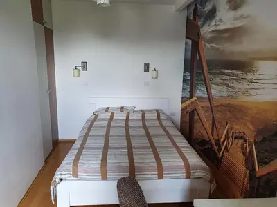 a bed in a room with a painting on the wall at Alo Alo Apartman 6 in Kruševac