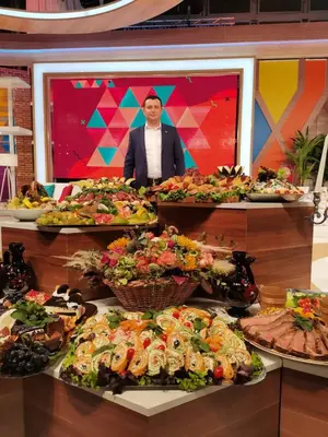 a man standing in front of a buffet of food at Idila in Kruševac
