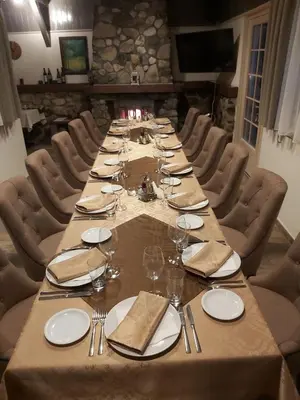 a long table with plates and wine glasses on it at Idila in Kruševac