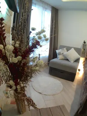 a living room with a couch and a vase with flowers at MIPS Milmari Resort Kopaonik in Kopaonik