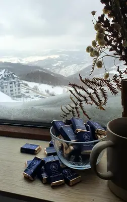a pile of blue chocolates on a table next to a window at MIPS Milmari Resort Kopaonik in Kopaonik