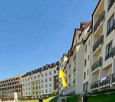a building with a yellow arrow sign in front of it at MIPS Milmari Resort Kopaonik in Kopaonik