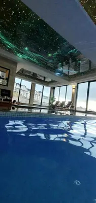 a large swimming pool with blue water in a building at MIPS Milmari Resort Kopaonik in Kopaonik