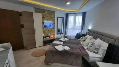 a bedroom with a large bed and a couch at MIPS Milmari Resort Kopaonik in Kopaonik