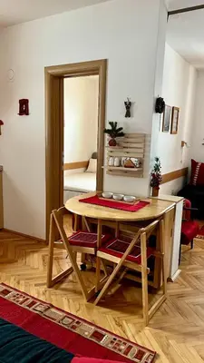 a living room with a table and a mirror at Vila Boris, Apartman Aleksej - Kopaonik in Kopaonik