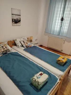 two twin beds in a room with blue mats on them at Apartman Domina in Kruševac