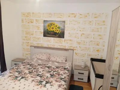 a bedroom with a bed and a painting on the wall at Apartman San in Vrnjačka Banja