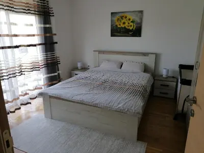 a bedroom with a bed and a window at Apartman San in Vrnjačka Banja