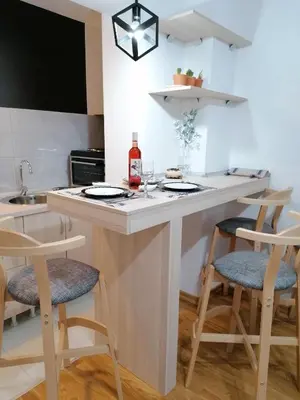 a kitchen with a counter with chairs and a sink at Apartman San in Vrnjačka Banja