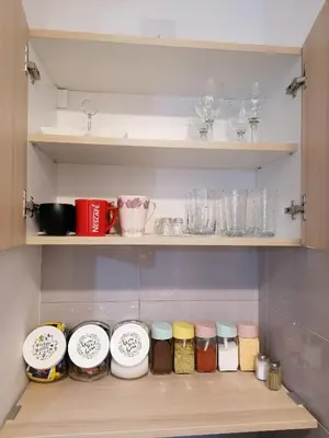 a shelf with jars and other items in a kitchen at Apartman San in Vrnjačka Banja