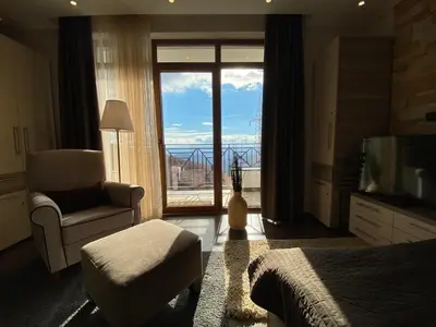 a bedroom with a bed and a chair and a large window at Milmari Mountain view - I11 in Kopaonik