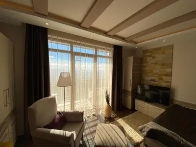 a living room with a couch and a large window at Milmari Mountain view - I11 in Kopaonik