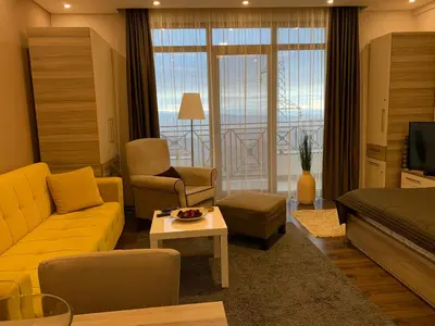 a living room with a yellow couch and a television at Milmari Mountain view - I11 in Kopaonik