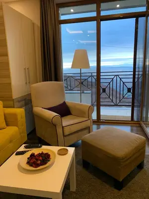 a living room with a chair and a table at Milmari Mountain view - I11 in Kopaonik