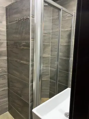 a shower with a glass door next to a sink at Milmari Mountain view - I11 in Kopaonik