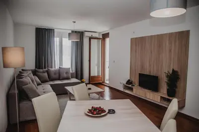 a living room with a couch and a table with chairs at Apartman Viva in Vrnjačka Banja
