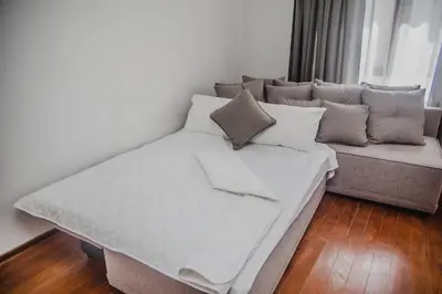 a large bed and a couch in a room at Apartman Viva in Vrnjačka Banja
