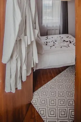 a bedroom with a bed with white sheets and a window at Apartman Viva in Vrnjačka Banja