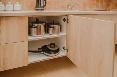 a kitchen with wooden cabinets with pots and pans at Apartman Viva in Vrnjačka Banja