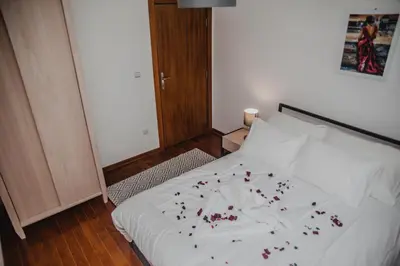 a bedroom with a bed with red flowers on it at Apartman Viva in Vrnjačka Banja
