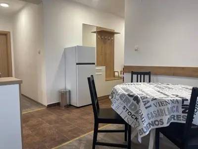 a kitchen with a table and a kitchen with a refrigerator at Desetka Kopaonik in Kopaonik