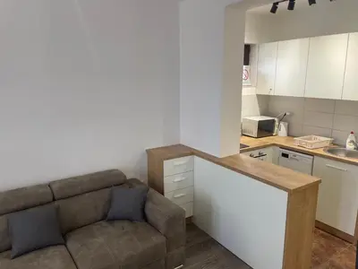 a living room with a couch and a kitchen at Desetka Kopaonik in Kopaonik