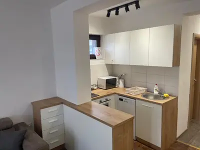a small kitchen with white cabinets and a sink at Desetka Kopaonik in Kopaonik