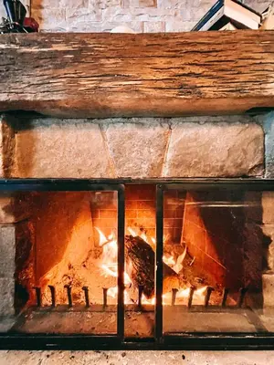 a brick fireplace with a fire in it at K2 Chalet in Kopaonik