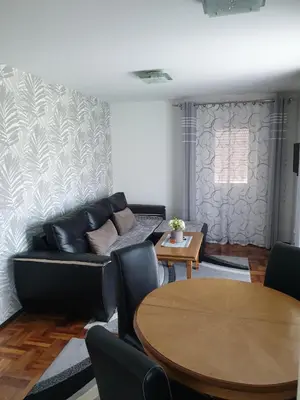 a living room with a couch and a table at Lux Apartman Ristić 1 in Soko Banja