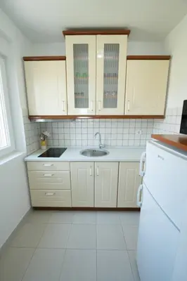 a white kitchen with a sink and a refrigerator at Lux Apartman Ristić 1 in Soko Banja