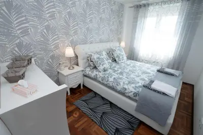 a small bedroom with a bed and a desk at Lux Apartman Ristić 1 in Soko Banja