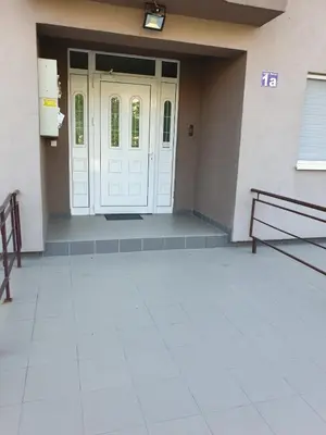 a pair of benches sitting in front of a door at Lux Apartman Ristić 1 in Soko Banja