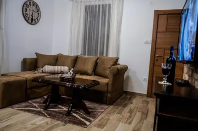 a living room with a brown couch and a table at Vila Rajski kutak Kopaonik in Kopaonik
