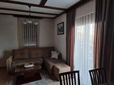 a living room with a couch and a table at Vila Rajski kutak Kopaonik in Kopaonik