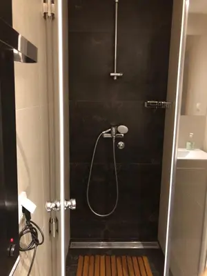 a shower in a bathroom with a black wall at Vila Irina Kopaonik - Apartman Jovana in Kopaonik