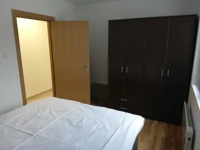a bedroom with a white bed and black cabinets at Vila Irina Kopaonik - Apartman Jovana in Kopaonik
