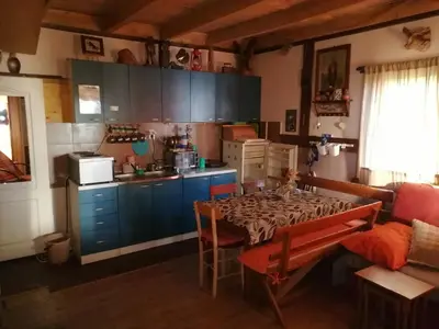 a kitchen with a table and a kitchen with blue cabinets at kuća za odmor marković in Kopaonik