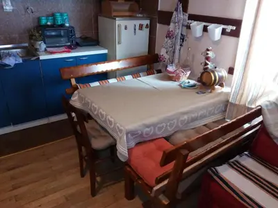 a table in a kitchen with a table and chairs at kuća za odmor marković in Kopaonik
