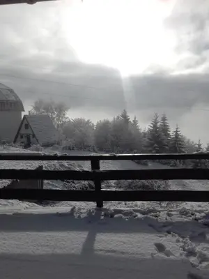 a fence covered in snow next to a barn at kuća za odmor marković in Kopaonik